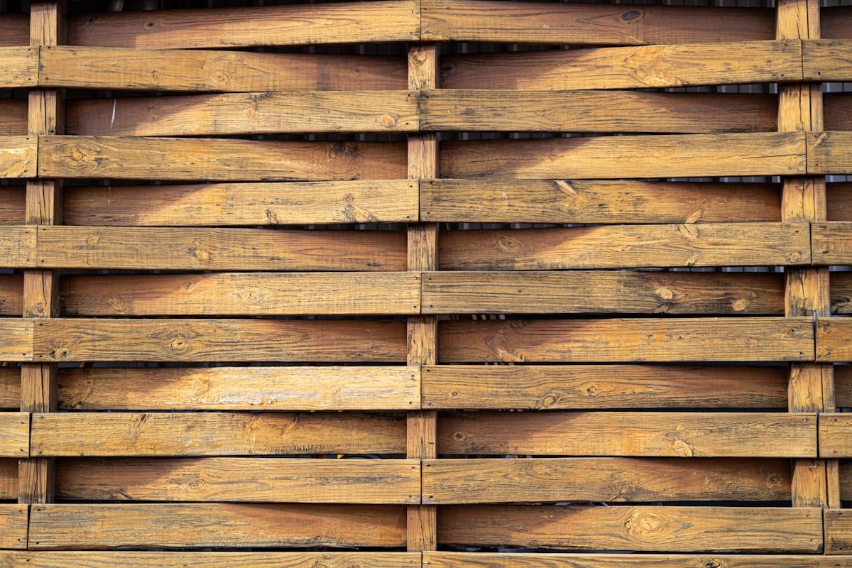 Modern fence made of horizontal wood slats with visible vertical support posts